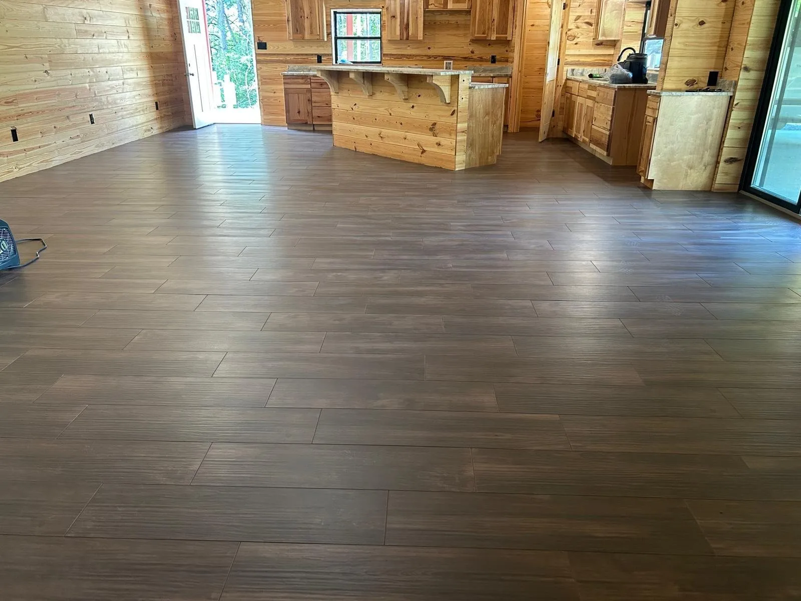 Open living room and kitchen finished in wood-look porcelain plank