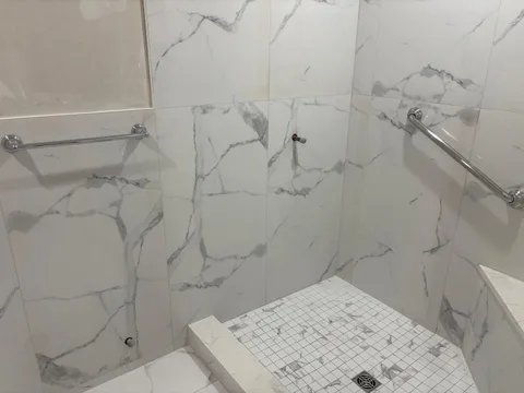 Shower detail — mosaic floor, grab bars, linear bench