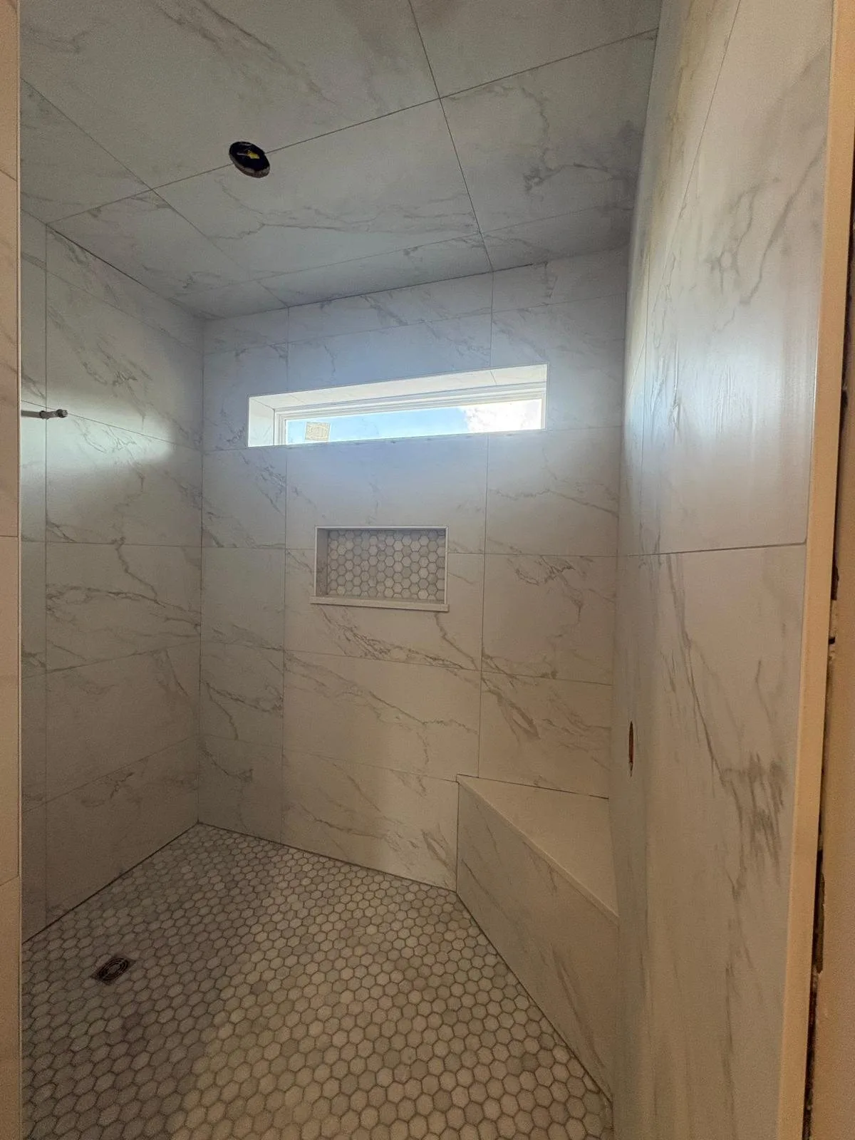 Finished shower with window, niche and hex mosaic floor