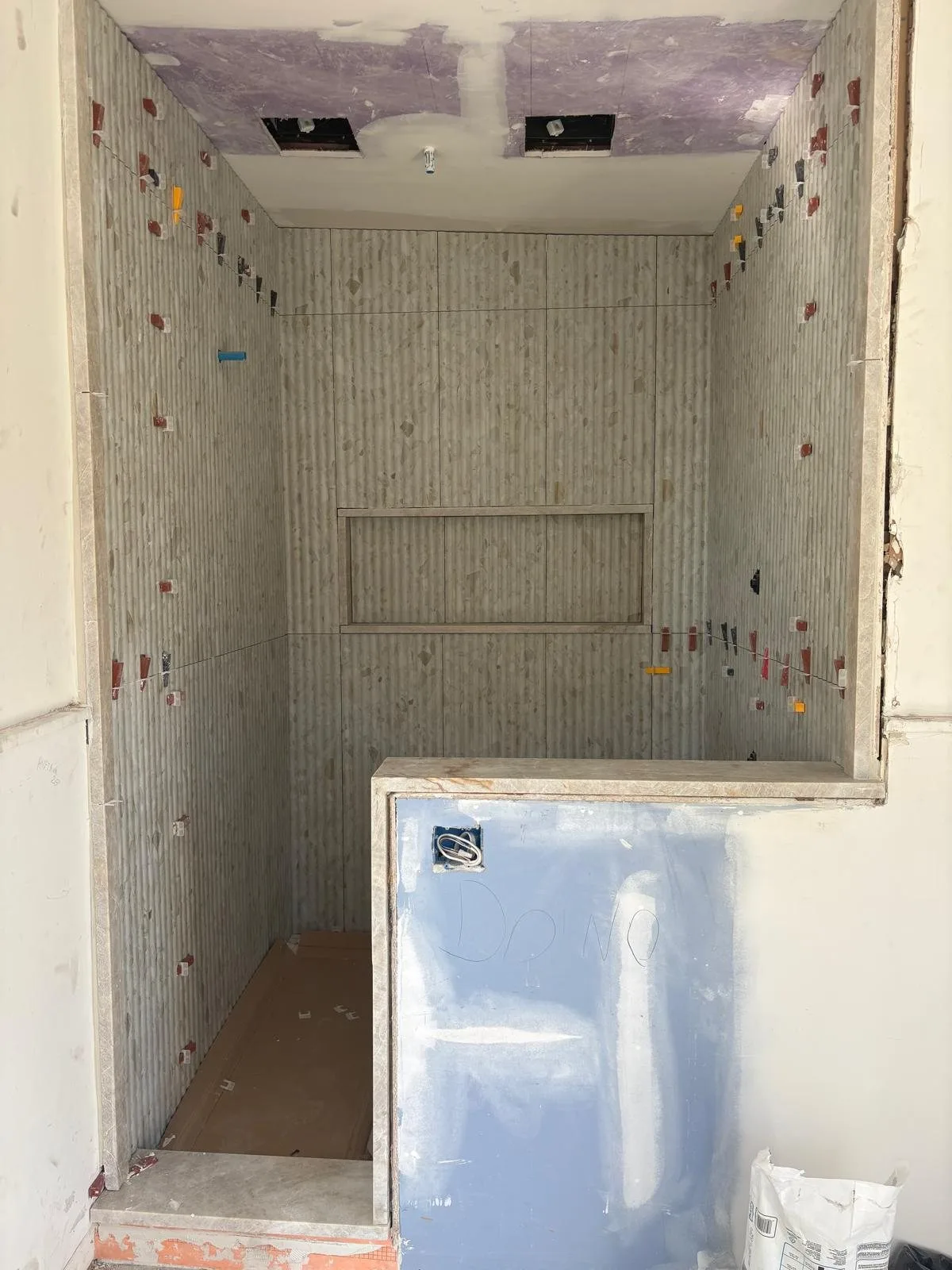 Fluted tile shower with long niche, before grout